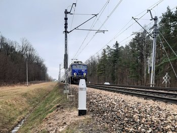 Urządzenie UOZ przy torach, widać nadjeżdżający pociąg, fot. Grzegorz Łubik