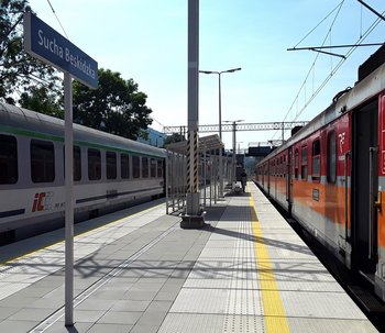Stacja Sucha Beskidzka Stacja Sucha Beskidzka - na peronie podróżny, po obu stronach stoją pociągi, fot. Józef Syc